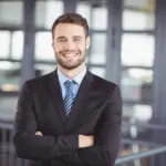 a man in a suit with his arms crossed
